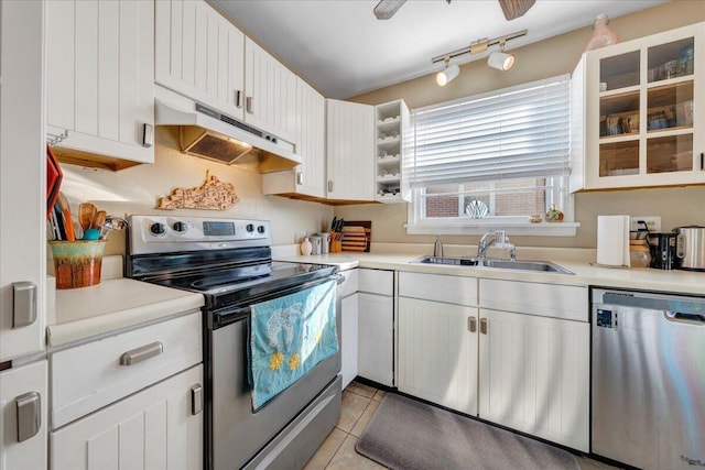 kitchen with sink, white cabinetry, light tile patterned floors, appliances with stainless steel finishes, and ceiling fan