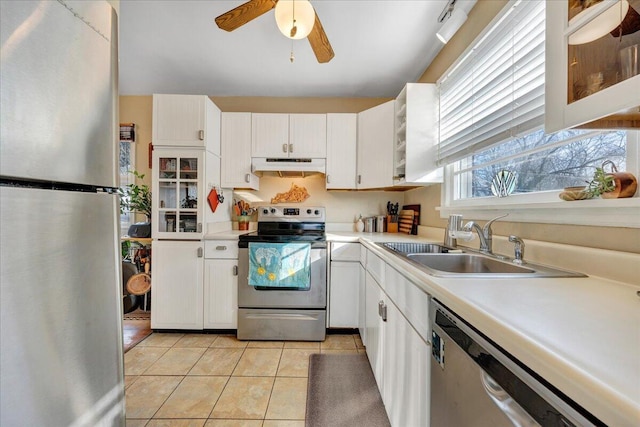 kitchen with sink, white cabinetry, light tile patterned floors, appliances with stainless steel finishes, and ceiling fan