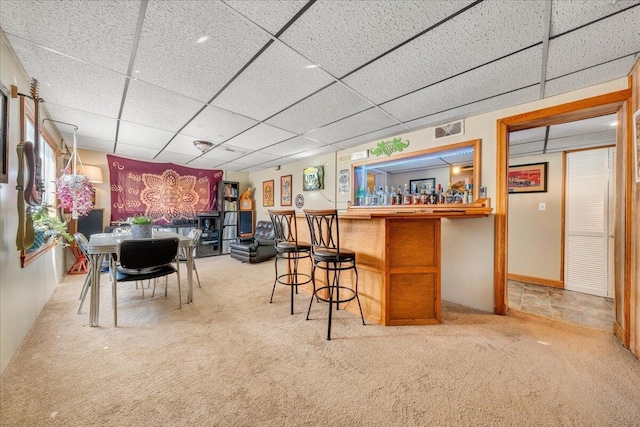 bar featuring carpet floors and a drop ceiling