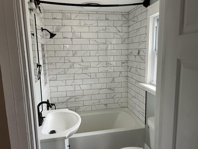 full bathroom with tiled shower / bath, sink, and toilet