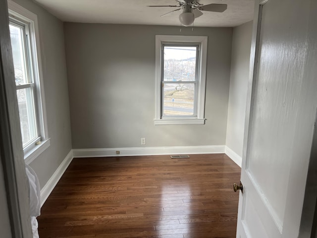 unfurnished room with ceiling fan and dark hardwood / wood-style flooring