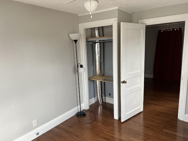 unfurnished bedroom featuring dark hardwood / wood-style flooring, ceiling fan, and a closet