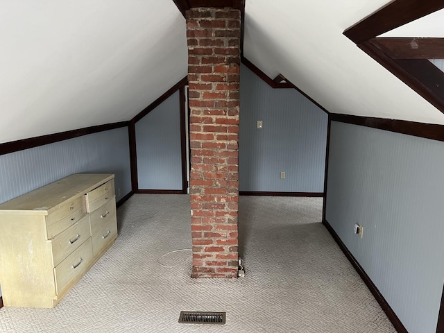 additional living space featuring lofted ceiling and light colored carpet