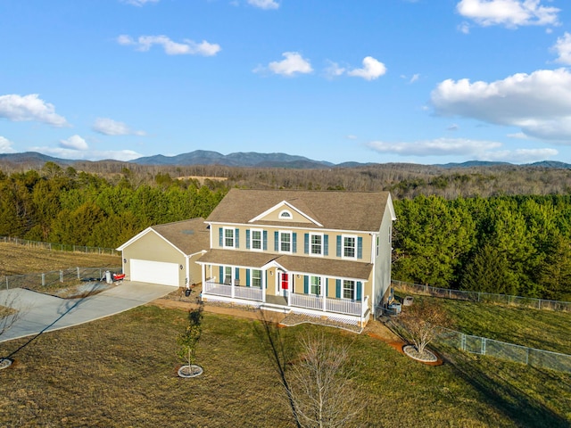 view of front facade with a mountain view, a garage, a front lawn, and a porch