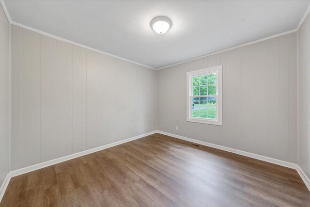 unfurnished room featuring baseboards, ornamental molding, dark wood-type flooring, and visible vents