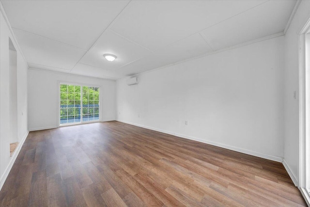 unfurnished room featuring wood finished floors, crown molding, and baseboards