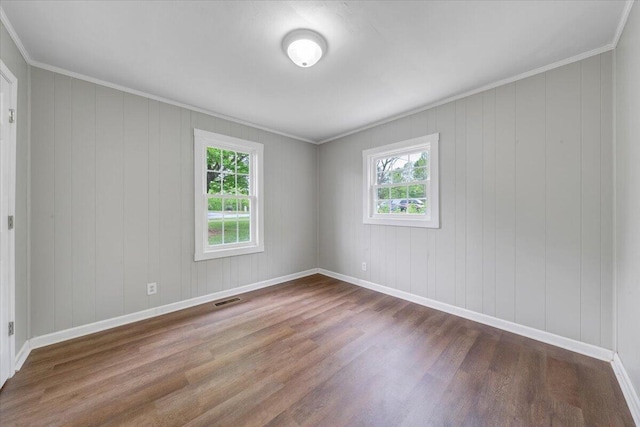 unfurnished room with baseboards, wood finished floors, visible vents, and plenty of natural light