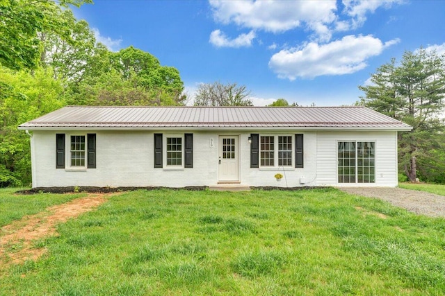 single story home with a front lawn, brick siding, and metal roof