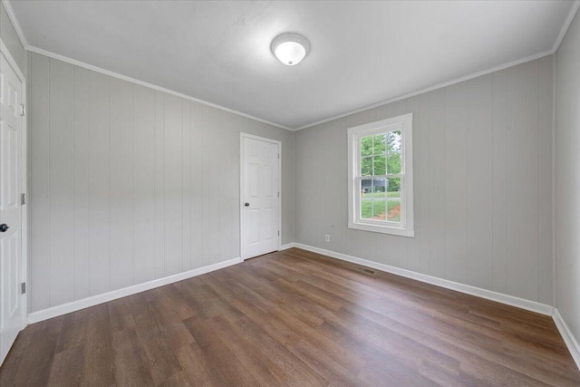 spare room featuring baseboards and dark wood finished floors