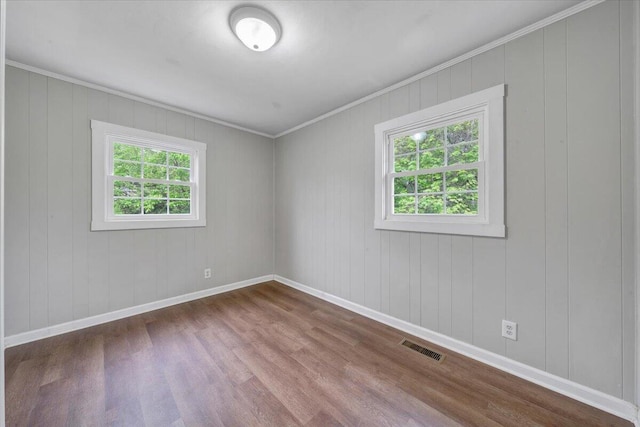unfurnished room with baseboards, visible vents, crown molding, and dark wood-style floors
