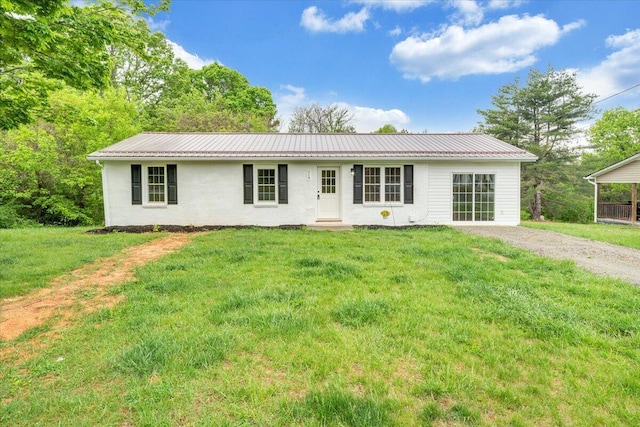 ranch-style home featuring a front lawn and metal roof