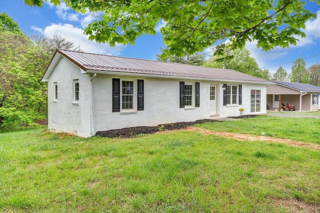 view of front facade with a front lawn, brick siding, and metal roof