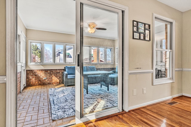 doorway featuring hardwood / wood-style floors, a healthy amount of sunlight, and ceiling fan