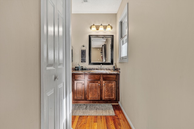 bathroom with vanity, hardwood / wood-style floors, and a textured ceiling