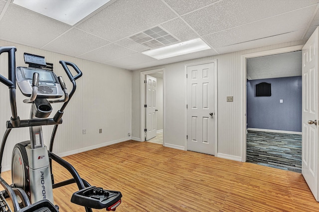 workout room featuring wood-type flooring and a drop ceiling