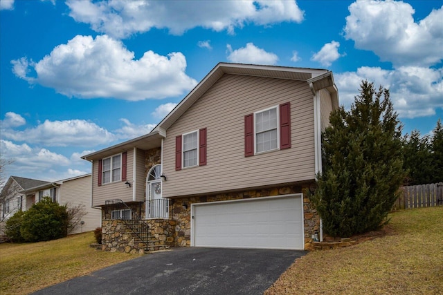 split foyer home featuring a garage and a front yard