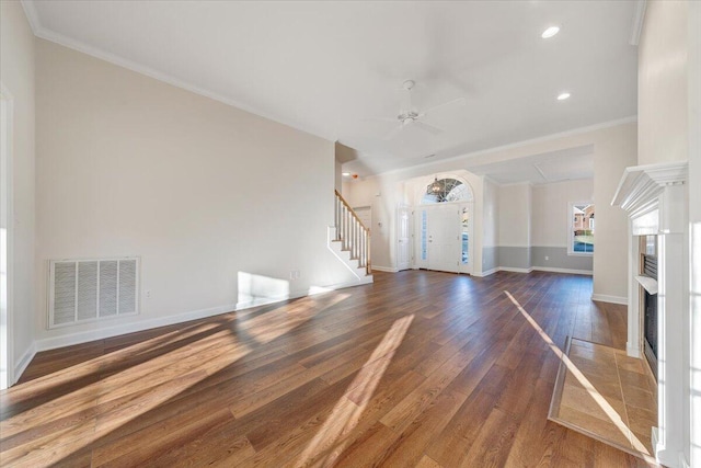 unfurnished living room with ceiling fan, ornamental molding, and dark hardwood / wood-style flooring