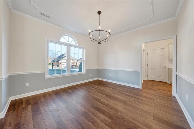 unfurnished room with crown molding, hardwood / wood-style floors, and an inviting chandelier