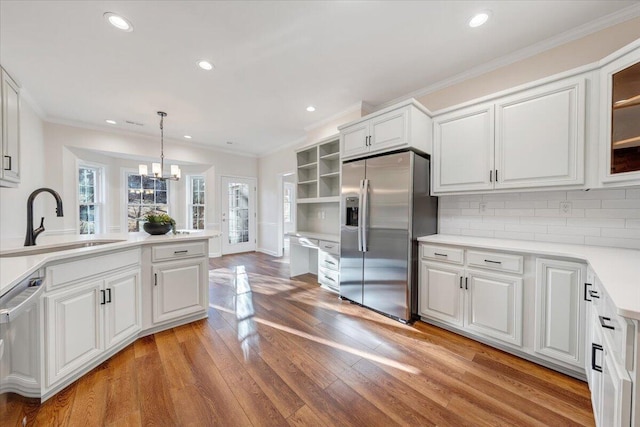 kitchen with hanging light fixtures, appliances with stainless steel finishes, and white cabinets