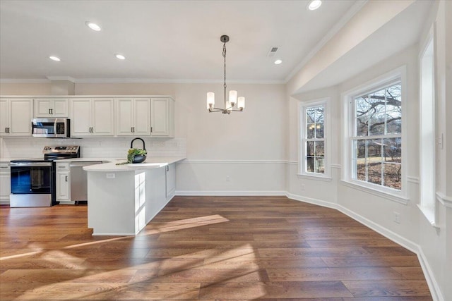 kitchen with stainless steel appliances, decorative light fixtures, white cabinets, and kitchen peninsula