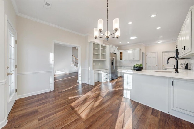 kitchen featuring sink, white cabinetry, dark hardwood / wood-style floors, stainless steel fridge with ice dispenser, and decorative light fixtures