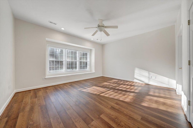 spare room featuring dark hardwood / wood-style flooring and ceiling fan