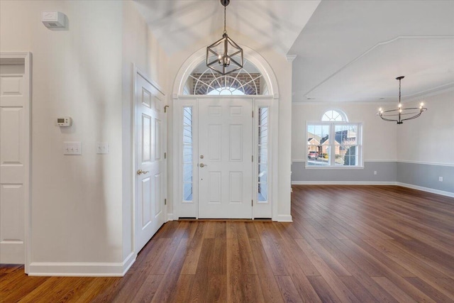 entryway with vaulted ceiling, dark hardwood / wood-style floors, and a chandelier