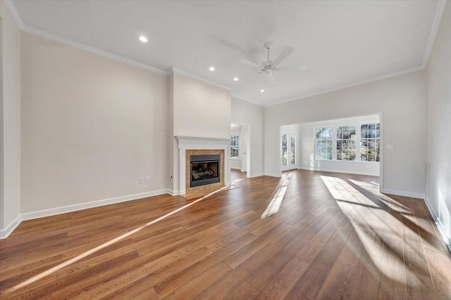 unfurnished living room featuring wood-type flooring, ornamental molding, and ceiling fan