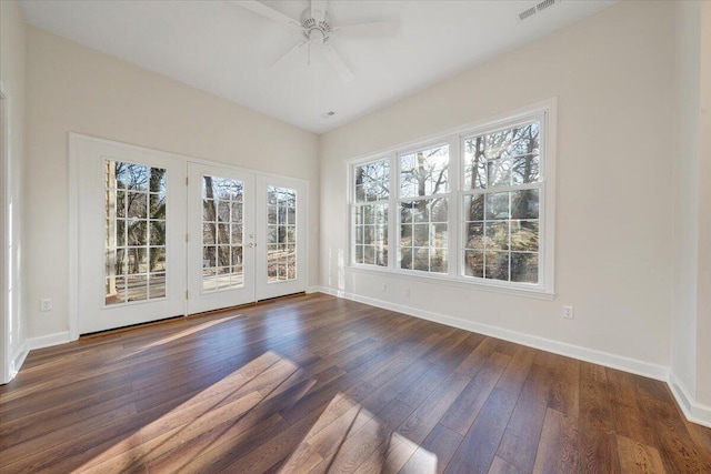 empty room featuring ceiling fan, a healthy amount of sunlight, and dark hardwood / wood-style floors