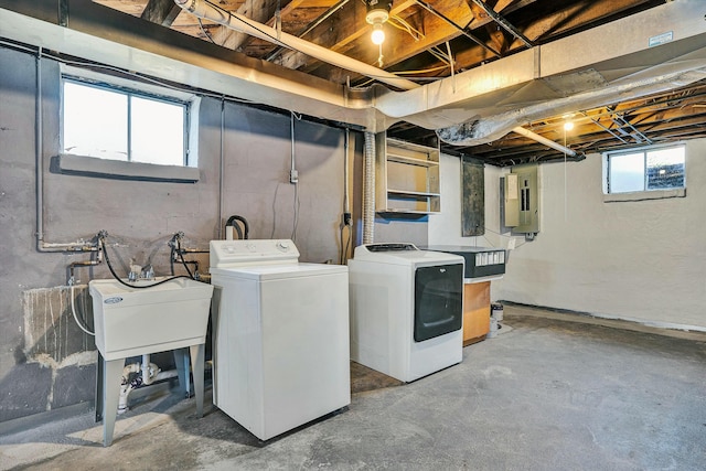 laundry area with sink, electric panel, and washer and clothes dryer