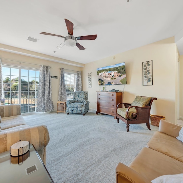 living room with ceiling fan and light colored carpet