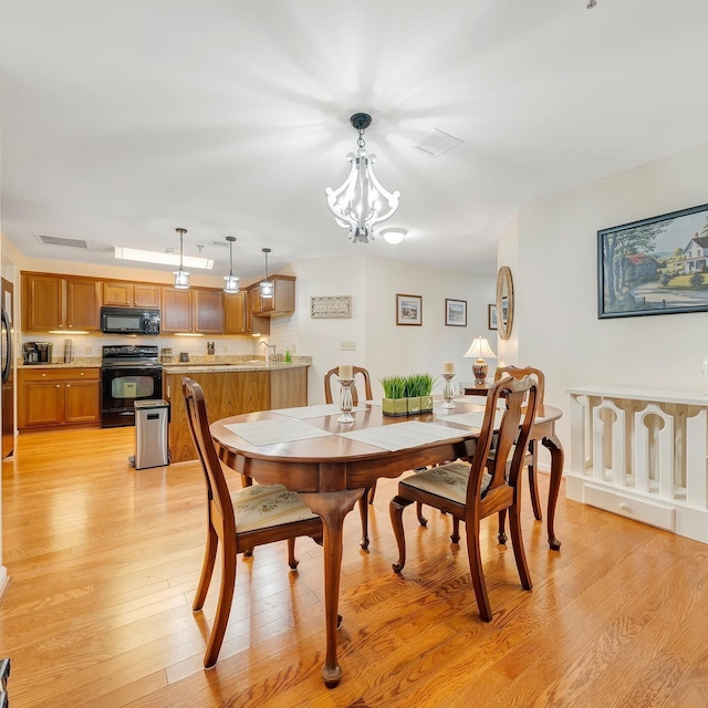 dining room featuring an inviting chandelier and light hardwood / wood-style floors