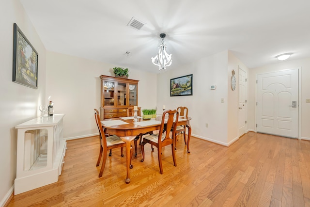 dining room featuring light hardwood / wood-style flooring and a chandelier