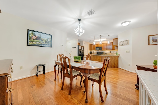 dining room featuring light hardwood / wood-style flooring and a notable chandelier