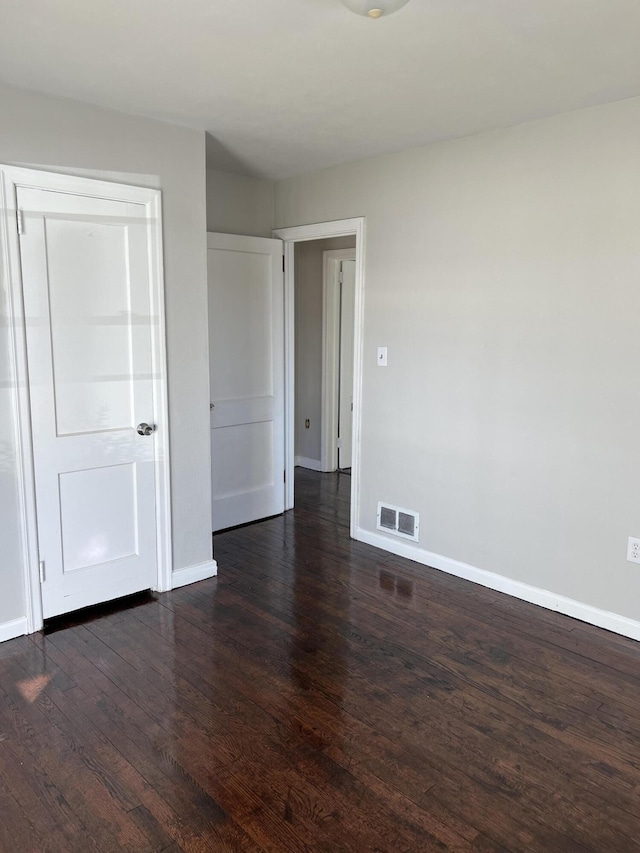 spare room with dark wood-type flooring