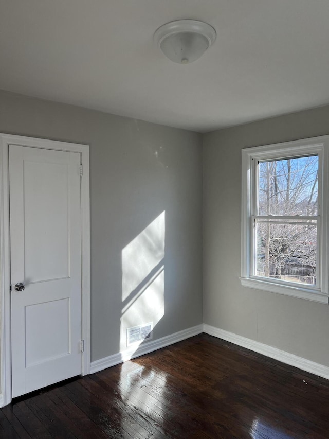 spare room featuring dark wood-type flooring