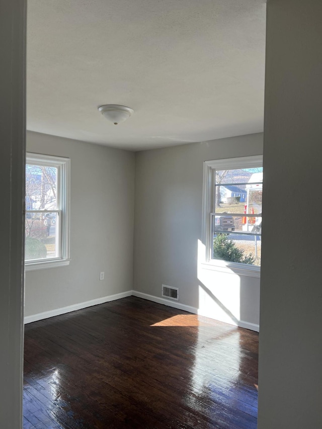 unfurnished room with dark wood-type flooring