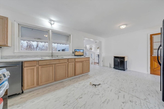 kitchen with marble finish floor, stainless steel dishwasher, light countertops, and a sink
