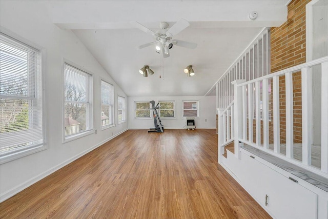 unfurnished living room featuring vaulted ceiling, wood finished floors, baseboards, and ceiling fan