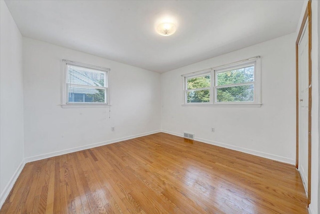 spare room with light wood finished floors, visible vents, baseboards, and a wealth of natural light