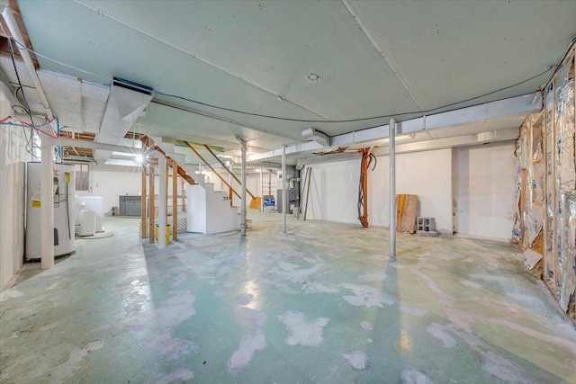 unfinished below grade area featuring stairs, gas water heater, and washer / dryer
