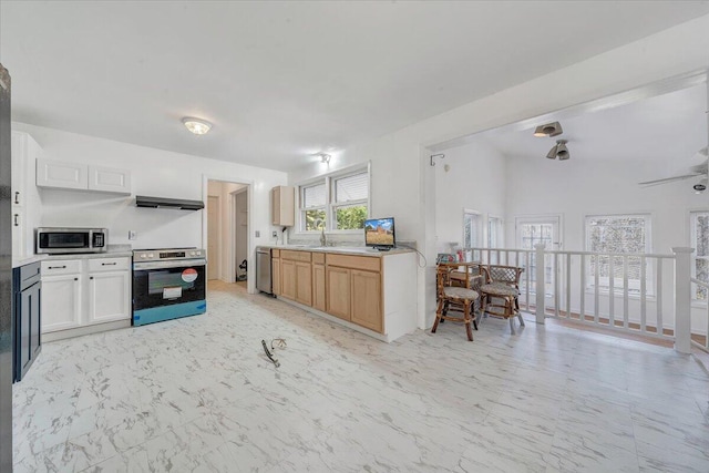 kitchen with light countertops, marble finish floor, appliances with stainless steel finishes, and range hood