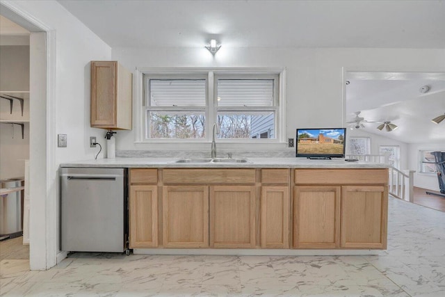 kitchen with marble finish floor, stainless steel dishwasher, light countertops, and a sink
