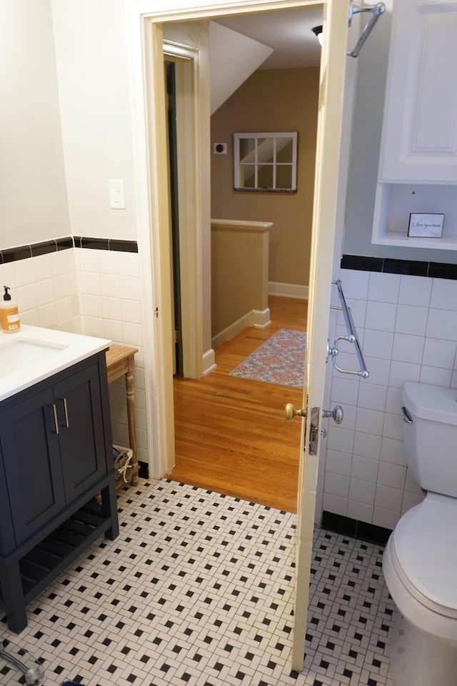 bathroom featuring tile walls, vanity, tile patterned flooring, and toilet