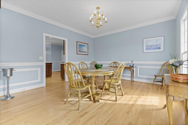 dining room with crown molding, a notable chandelier, and light hardwood / wood-style flooring