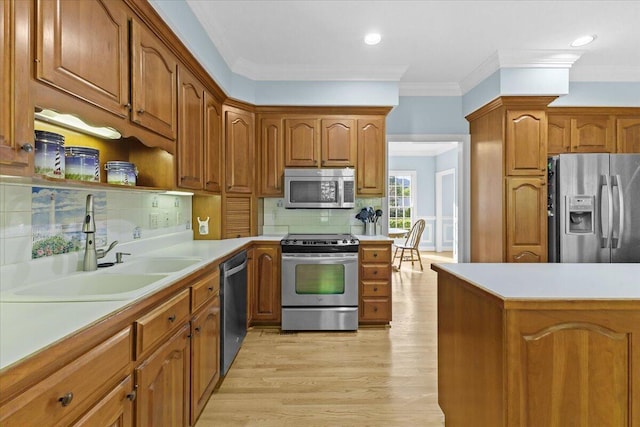 kitchen with sink, stainless steel appliances, ornamental molding, decorative backsplash, and light wood-type flooring