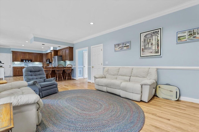 living room with crown molding and light wood-type flooring