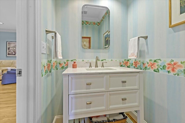 bathroom with crown molding, vanity, and wood-type flooring