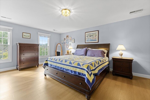 bedroom featuring multiple windows and light hardwood / wood-style floors