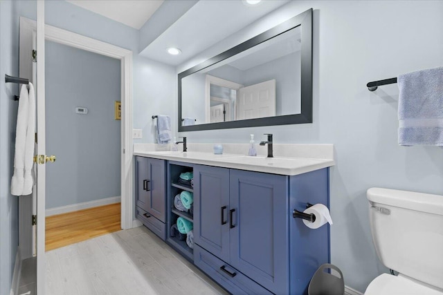 bathroom with vanity, hardwood / wood-style flooring, and toilet